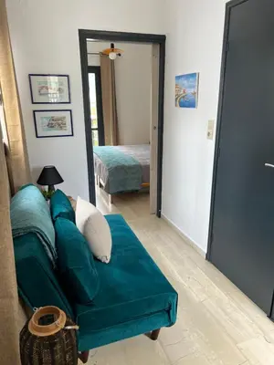 a living room with a couch and a bedroom at Azure Sea Bliss at The Erodios Apartments in Kalyves