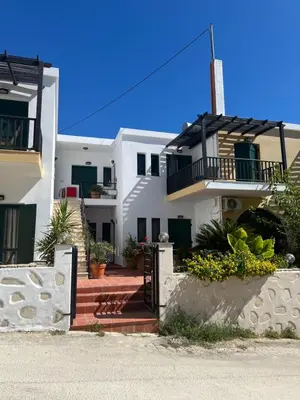 a white house with a staircase in front of it at Azure Sea Bliss at The Erodios Apartments in Kalyves