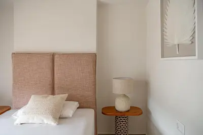 a bedroom with a bed and a table with a lamp at Iris Luxury Apartment in Chania Town
