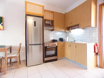 a kitchen with a stainless steel refrigerator and a table at Peris #2 - Souda in Souda