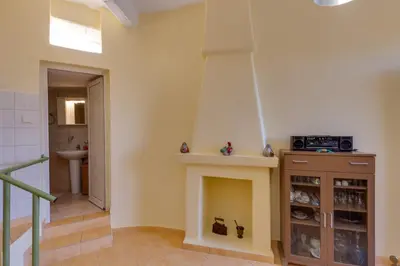 a living room with a fireplace and a sink at The Yellow Veranda - Close to Ancient Olive Tree of Vouves in Áno Voúvai
