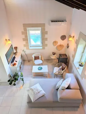 a living room with a couch and a tv at Villa Naiades Traditional Cretan Stone House with private Pool and Garden in Chania in Arménoi