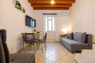 a living room with a couch and a table at Sea & City - Luxury Maisonette Steps from the Beach with Private Terrace in Chania Town