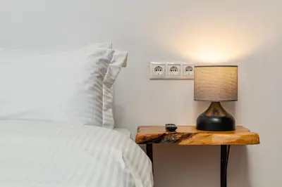 a bed with a table with a lamp on it at Sea & City - Luxury Maisonette Steps from the Beach with Private Terrace in Chania Town