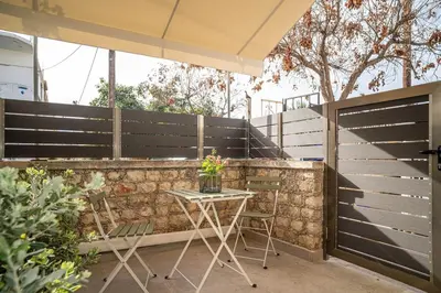 a patio with a table and a fence at Panterra-Chania Center in Chania Town