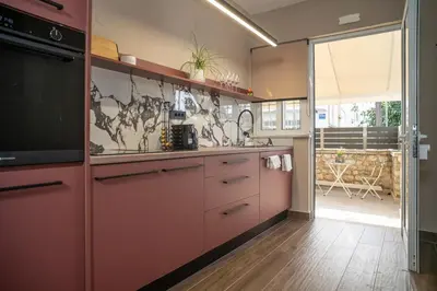 a kitchen with pink cabinets and a large window at Panterra-Chania Center in Chania Town