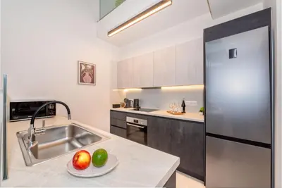 a kitchen with a sink and a stainless steel refrigerator at Lavender Loft in Chania Town