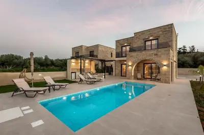a house with a swimming pool in front of a house at Golden Silence in Plataniás