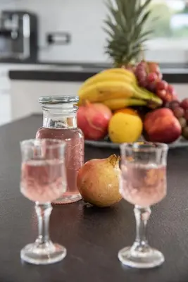 a table with two glasses and a plate of fruit at Adriana Horizon Villa, Pool & Hillside View in Galatás