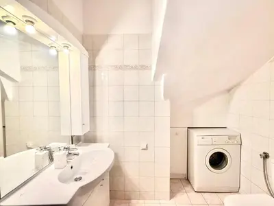 a white bathroom with a sink and a washing machine at Casa Eygenia in Galatás