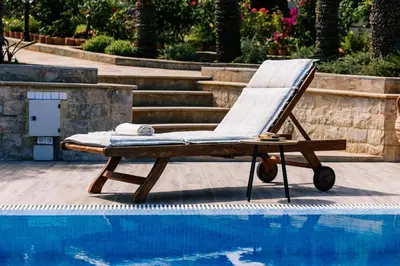 a lounge chair sitting next to a swimming pool at Casa Eygenia in Galatás