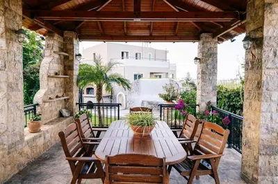 a wooden table and chairs on a patio at Casa Eygenia in Galatás