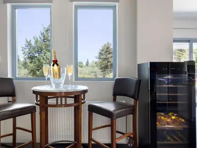 a kitchen with a table with a bottle of wine at Holiday Home Villa vacanze Agave Creta con piscina privata by Interhome in Litsárdha