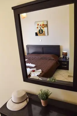 a mirror reflecting a bedroom with a bed and a hat at Apartment Charmante Ferienwohnung Rubini 2 by Interhome in Agia Marina Nea Kydonias