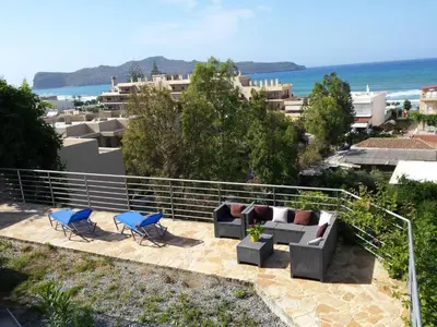 a patio with couches and chairs and the ocean at Apartment Moderne Wohnung Rubini 3 by Interhome in Chania Town