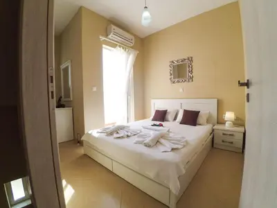 a bedroom with a bed with white sheets and a window at Apartment Rubini 1 by Interhome in Agia Marina Nea Kydonias
