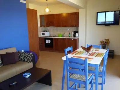 a kitchen and a living room with a table and chairs at Apartment Gemütliche Ferienwohnung Rubini 4 by Interhome in Agia Marina Nea Kydonias