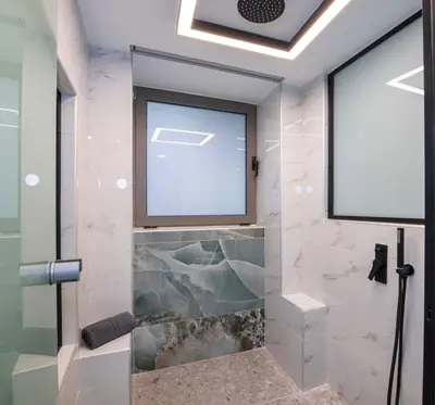a bathroom with a glass shower with a window at Chania Luxury City Retreat , Hammam & outdoor Jacuzzi in Chania Town