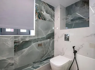 a bathroom with a white toilet and a marble wall at Chania Luxury City Retreat , Hammam & outdoor Jacuzzi in Chania Town