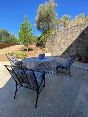 two chairs and a table in front of a stone wall at Ellie's Kantanos in Kántanos