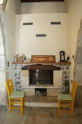 a living room with a fireplace and two chairs at Stone-Built Traditional Villa with Pool in Sfakia in Ímbros