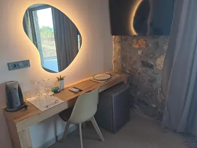 a desk with a mirror and a chair in a room at Castella Luxe in Loutro