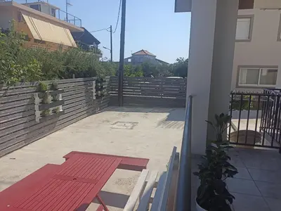 a red bench on a balcony of a house at Ifigenias House in Kissamos