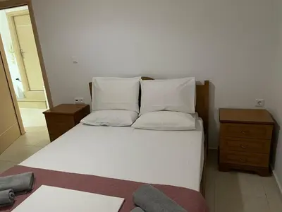 a bedroom with a bed with white sheets and pillows at Ifigenias House in Kissamos