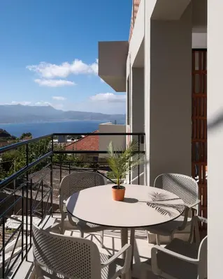 a balcony with a table and chairs and a view of the ocean at Raviewha Luxury Apartments 3 in Ravdhoúkha