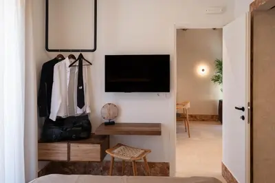 a room with a desk and a tv and a closet at Raviewha Luxury Apartments 3 in Ravdhoúkha