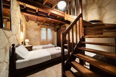 a bedroom with a bed and a staircase in a building at Villa Levedeli in Nerokhórion