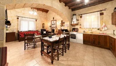 a kitchen and living room with a table and chairs at Villa Levedeli in Nerokhórion