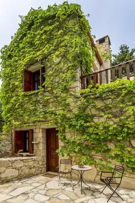 a stone building with chairs and a table in front of it at Manoli's House in Douliana