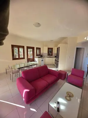 a living room with a red couch and a table at Villa Anna Gaia In Tzivaras in Tsivarás
