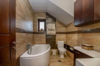 a bathroom with a tub and a toilet and a sink at Villa Chrysseva in Plátanos