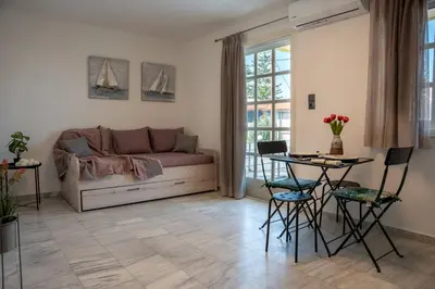 a living room with a couch and a table and chairs at REN Apartment in Stalos