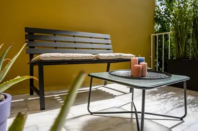 a table with two candles on it next to a bench at REN Apartment in Stalos