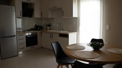 a kitchen with a table and chairs and a kitchen with a sink at Elaya Experience in Kamisianá