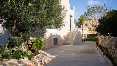 a white building with a staircase and a tree at Elaya Experience in Kamisianá