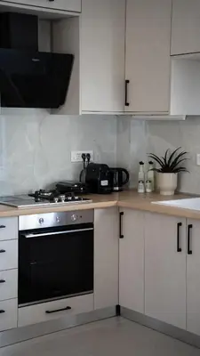 a kitchen with white cabinets and a black oven at Elaya Experience in Kamisianá