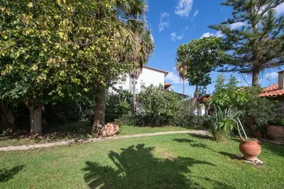 a yard with trees and a white house at Esperado Gardens Maleme in Maleme