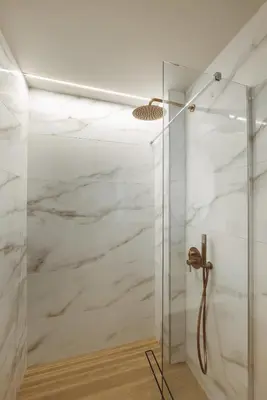 a shower with marble walls and a glass door at Madre Tierra Boutique Villas 3 & 4 in Potistíria