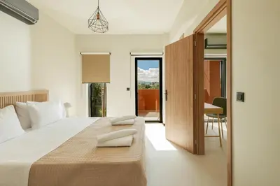 a bedroom with a bed and a table and a desk at Madre Tierra Boutique Villas 3 & 4 in Potistíria