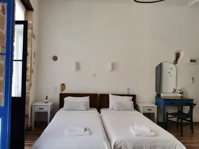 two beds in a room with white walls at casa di pietra in Chania Town