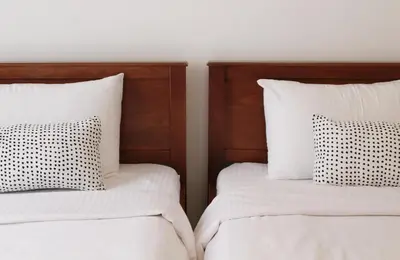 two beds with white sheets and black and white pillows at casa di pietra in Chania Town