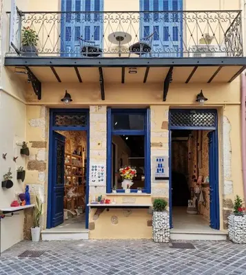 a shop with blue doors and a balcony at casa di pietra in Chania Town
