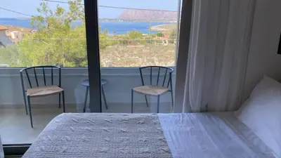 a bedroom with a bed and a view of the ocean at Two Seaview Villas With Elegant Design in Agios Onoufrios