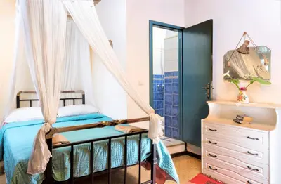 a bedroom with a canopy bed and a dresser at House Minoos in Chania Town