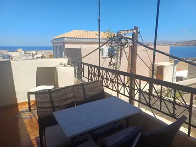 a patio with a table and chairs on a balcony at House Minoos in Chania Town
