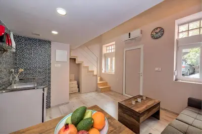 a kitchen and living room with a bowl of fruit on a table at Rea Studio 1 in Chania Town